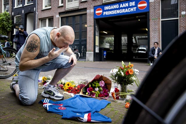 <p>A man pays tribute to Dutch crime reporter Peter R de Vries in the Lange Leidsedwarsstraat in Amsterdam</p>