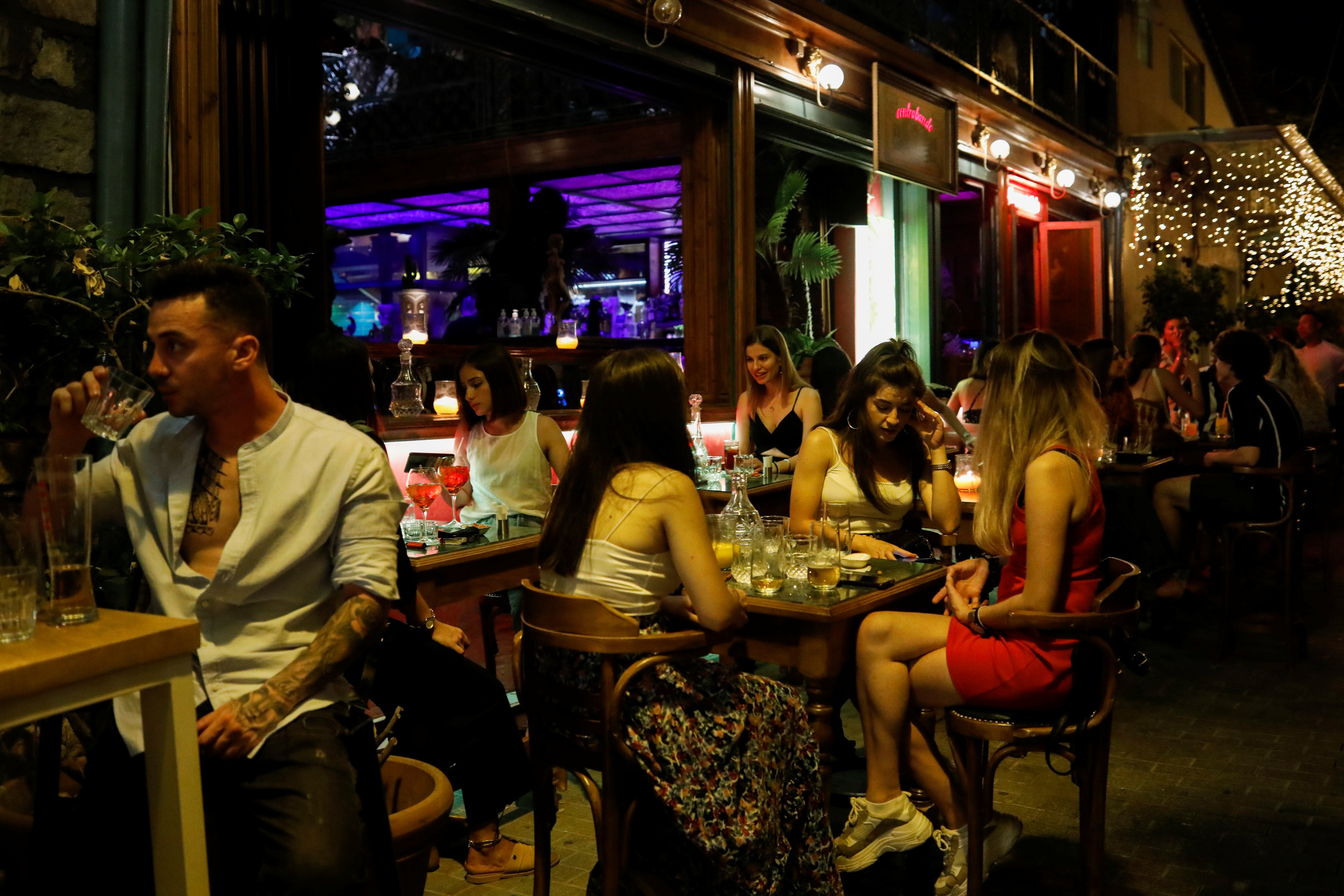 People sitting in a bar in Athens, Greece – under reimposed Covid restrictions, only seated customers will permitted