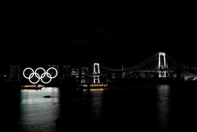 <p>Boats sail past the giant Olympic rings and the Rainbow Bridge on the waterfront area of Odaiba Marine Park</p>