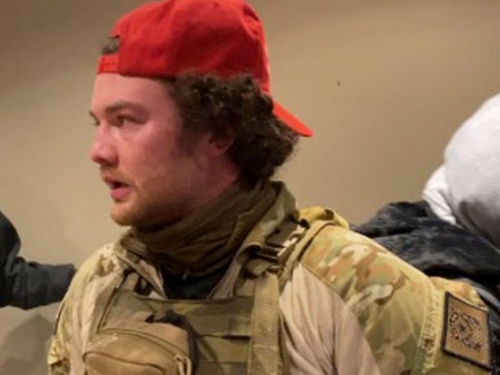 Robert Morss, 27, in tactical gear and a red MAGA hat during the Capitol riot. Mr Morss has been arrested and charged for his participation in the attack.
