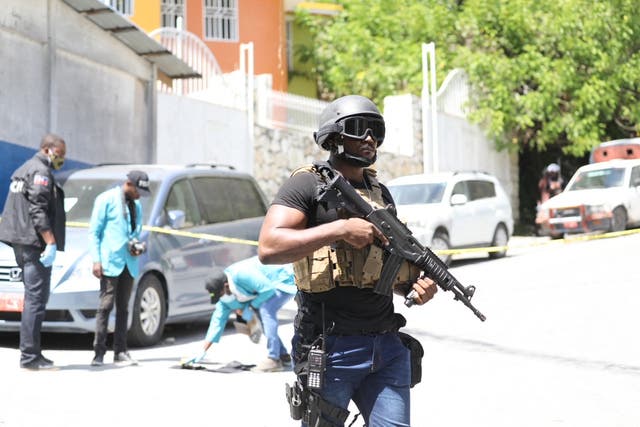 <p>Members of the Haitian police and forensics look for evidence outside of the presidential residence </p>