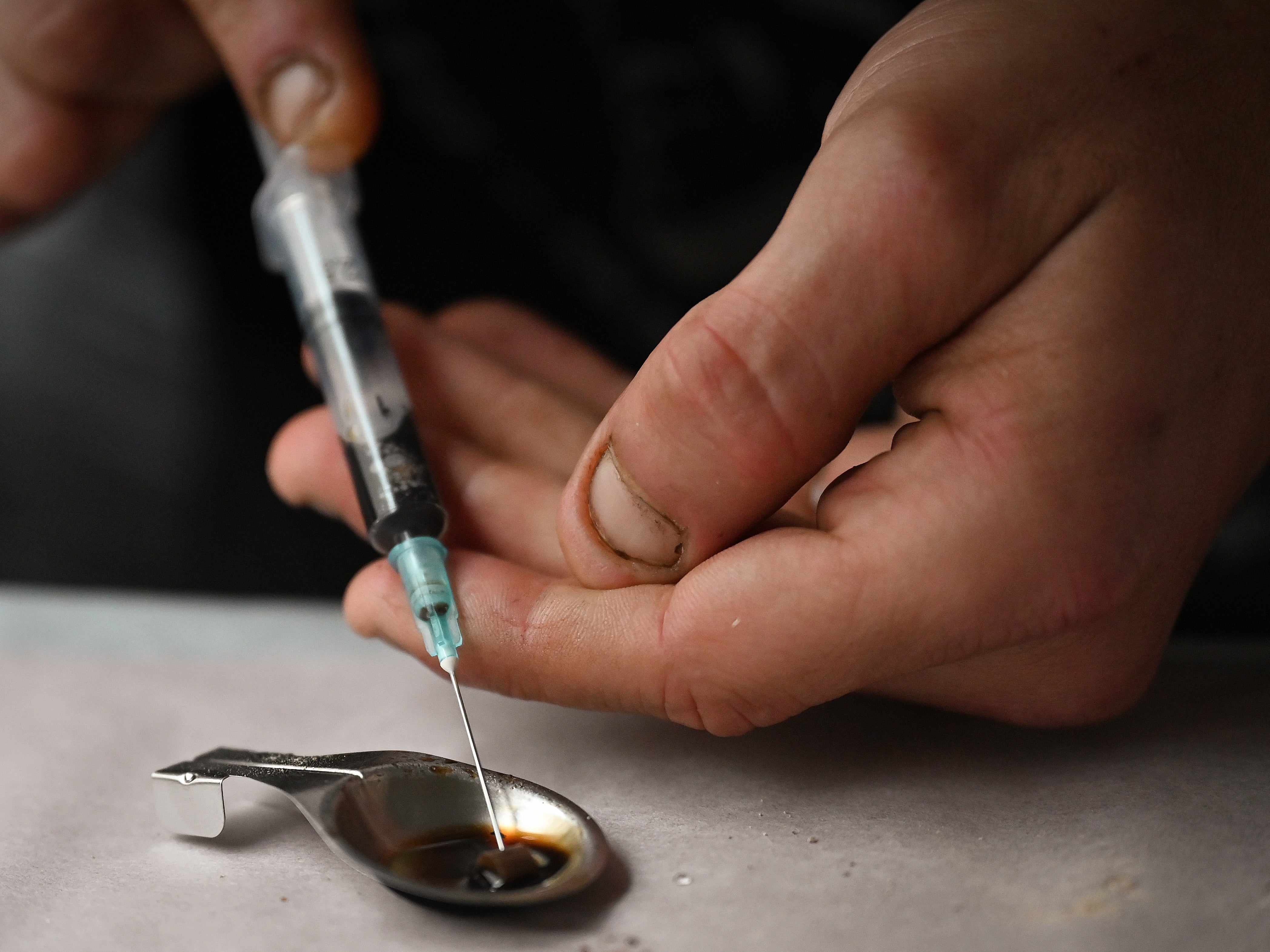 Drug users prepare heroin before injecting, while inside a safe consumption van