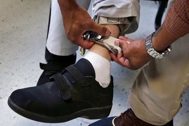 <p>Staff check the ankle strap of an electrical shocking device on a student during an exercise programme at the Judge Rotenberg Educational Center in Canton</p>