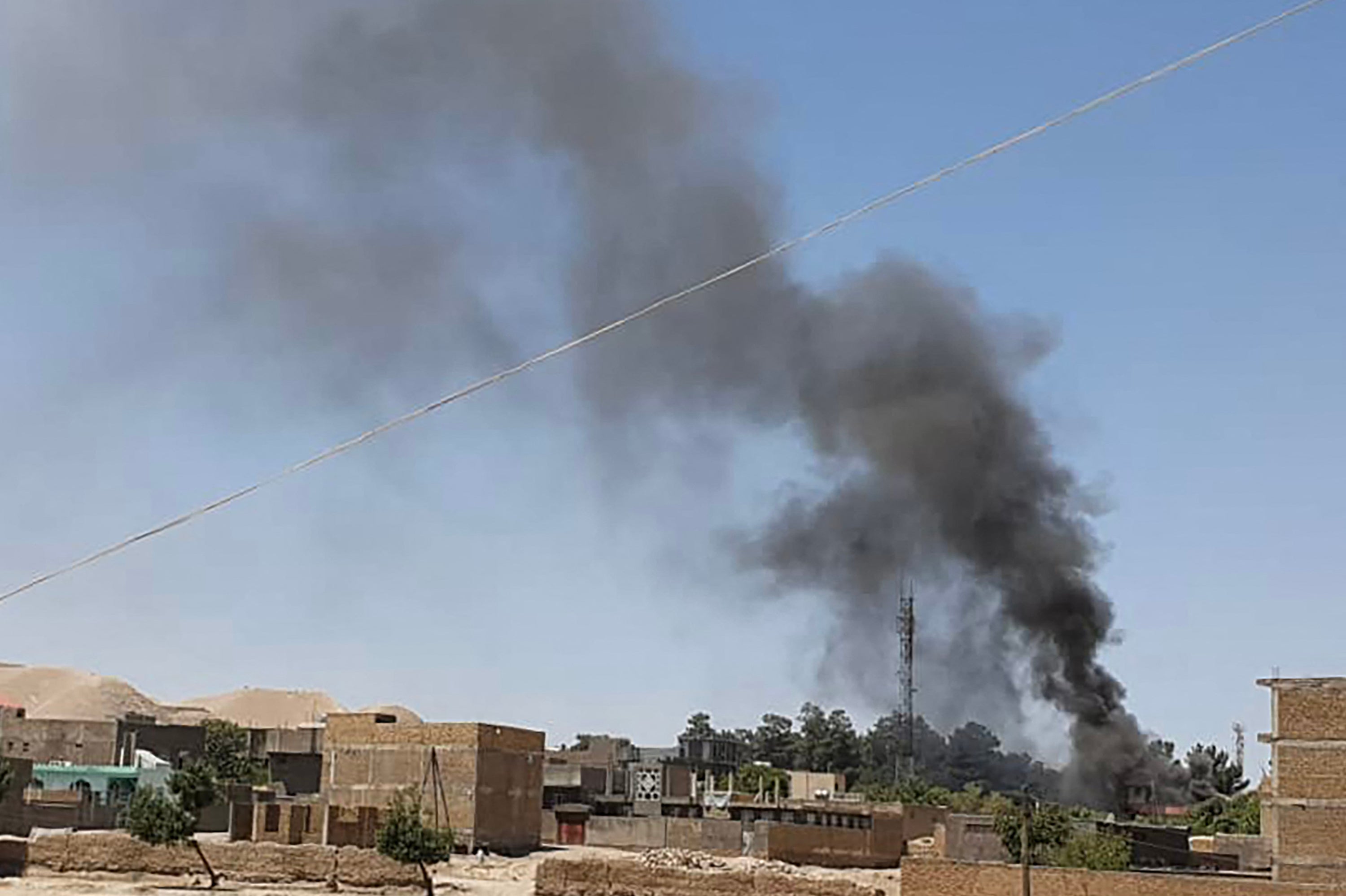 A smoke plume rises from houses amid ongoing fighting between Afghan security forces and Taliban fighters in the western city of Qala-i-Naw, the capital of Badghis province