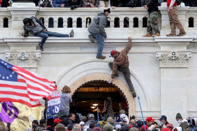 <p>A mob of supporters of then President Donald Trump fights with members of law enforcement at a door they broke open as they storm the Capitol Building in Washington, on 6 January 2021</p>