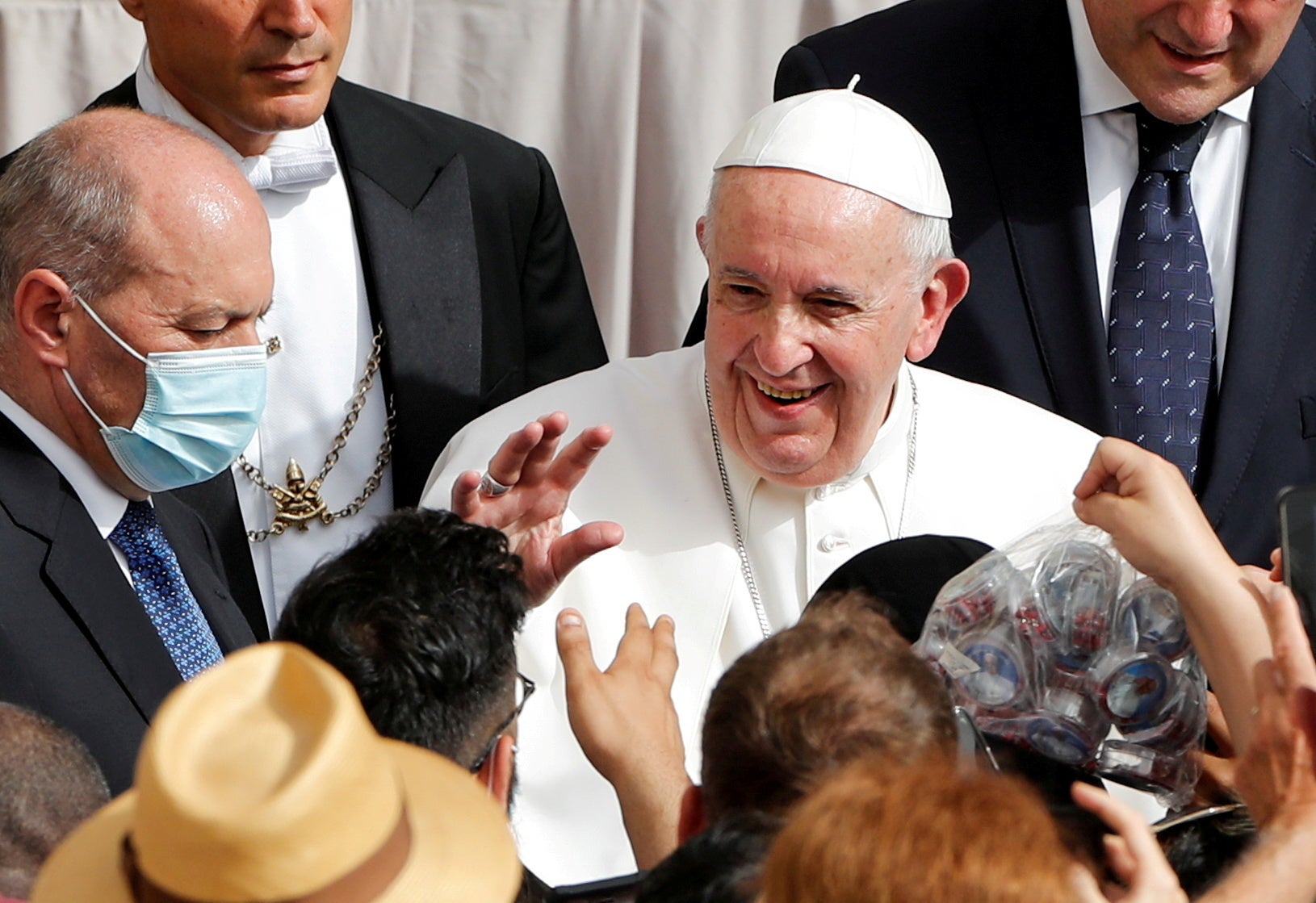 Pope Francis greets people, as he arrives at the San Damaso courtyard at the Vatican for the weekly general audience in mid-June this year