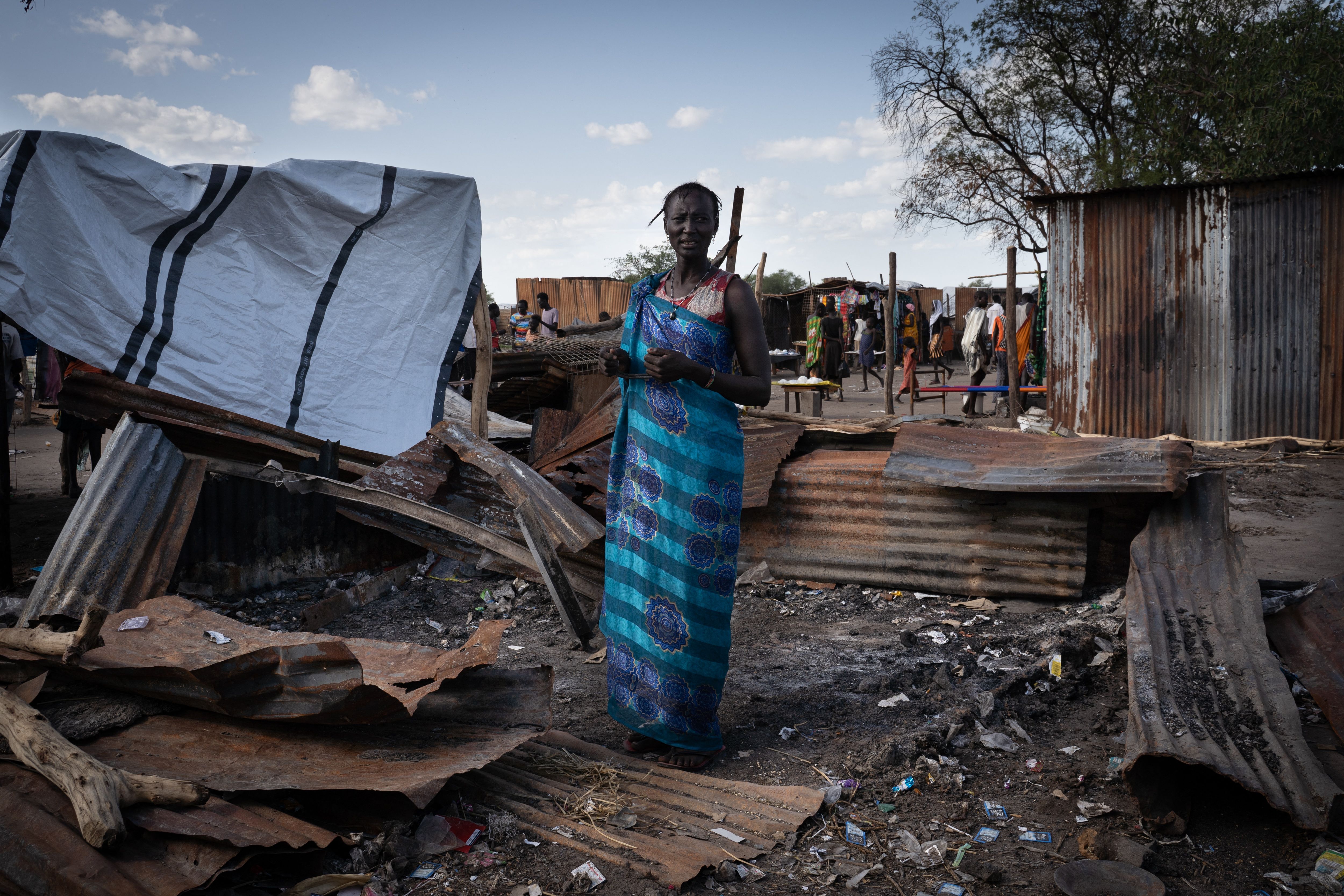 A woman from the Murle ethnic group stands at her destroyed tea shop in Gumuruk, South Sudan, on 10 June, 2021, after her village was attacked by an armed youth group.