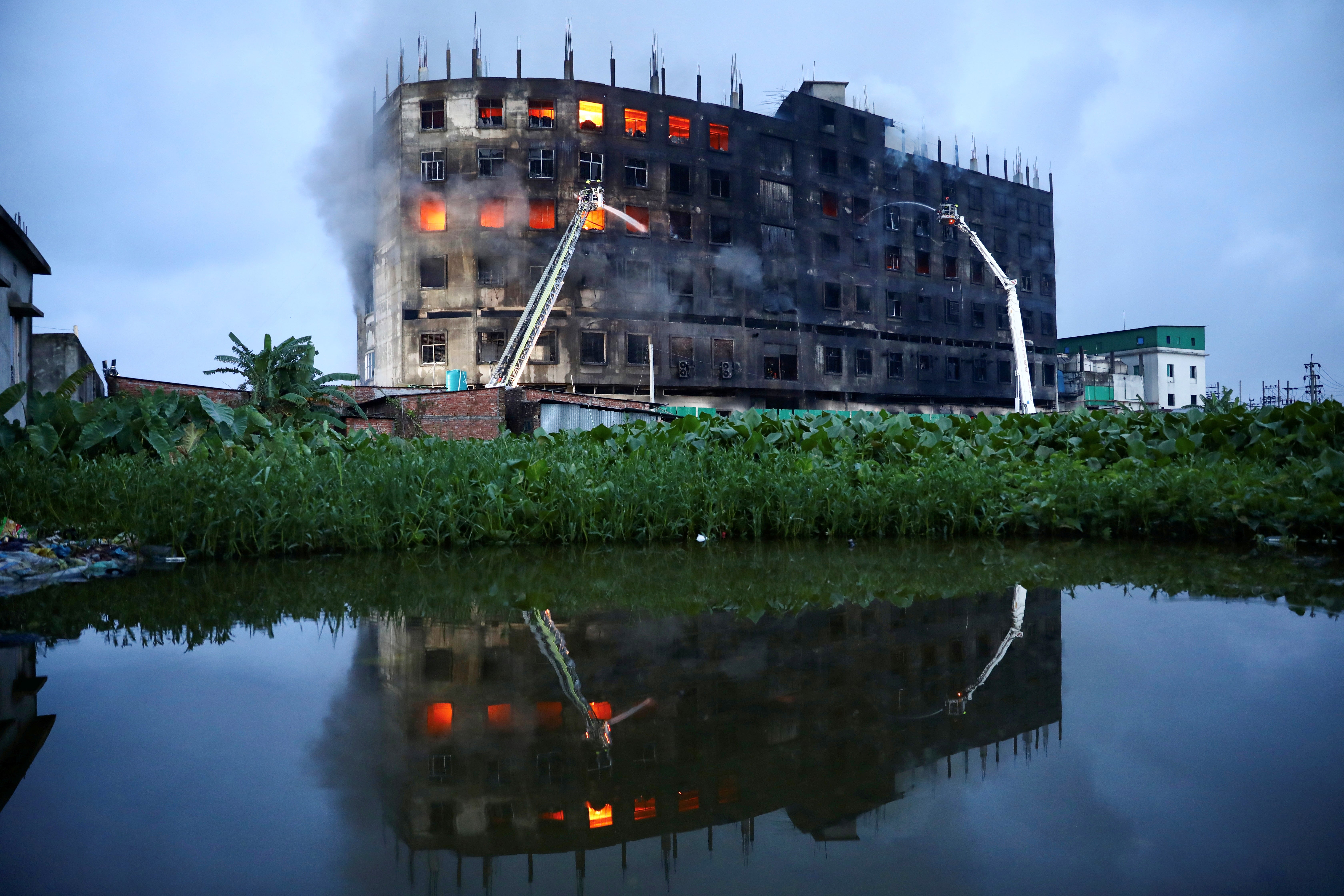Flames rise the morning after a fire broke out at a factory on the outskirts of Dhaka, Bangladesh