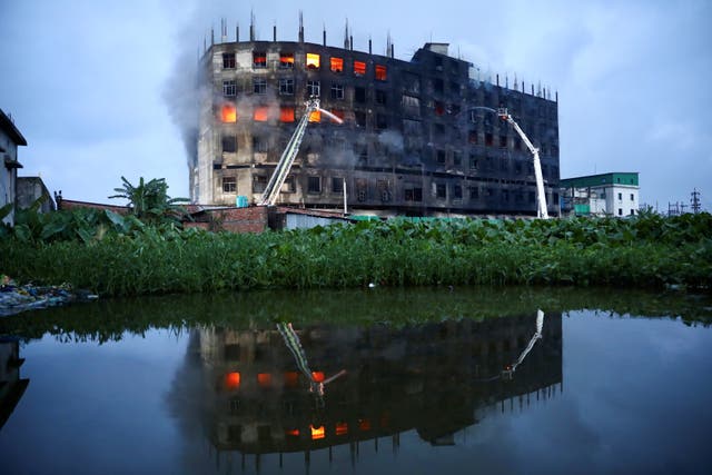 <p>Flames rise the morning after a fire broke out at a factory on the outskirts of Dhaka, Bangladesh</p>