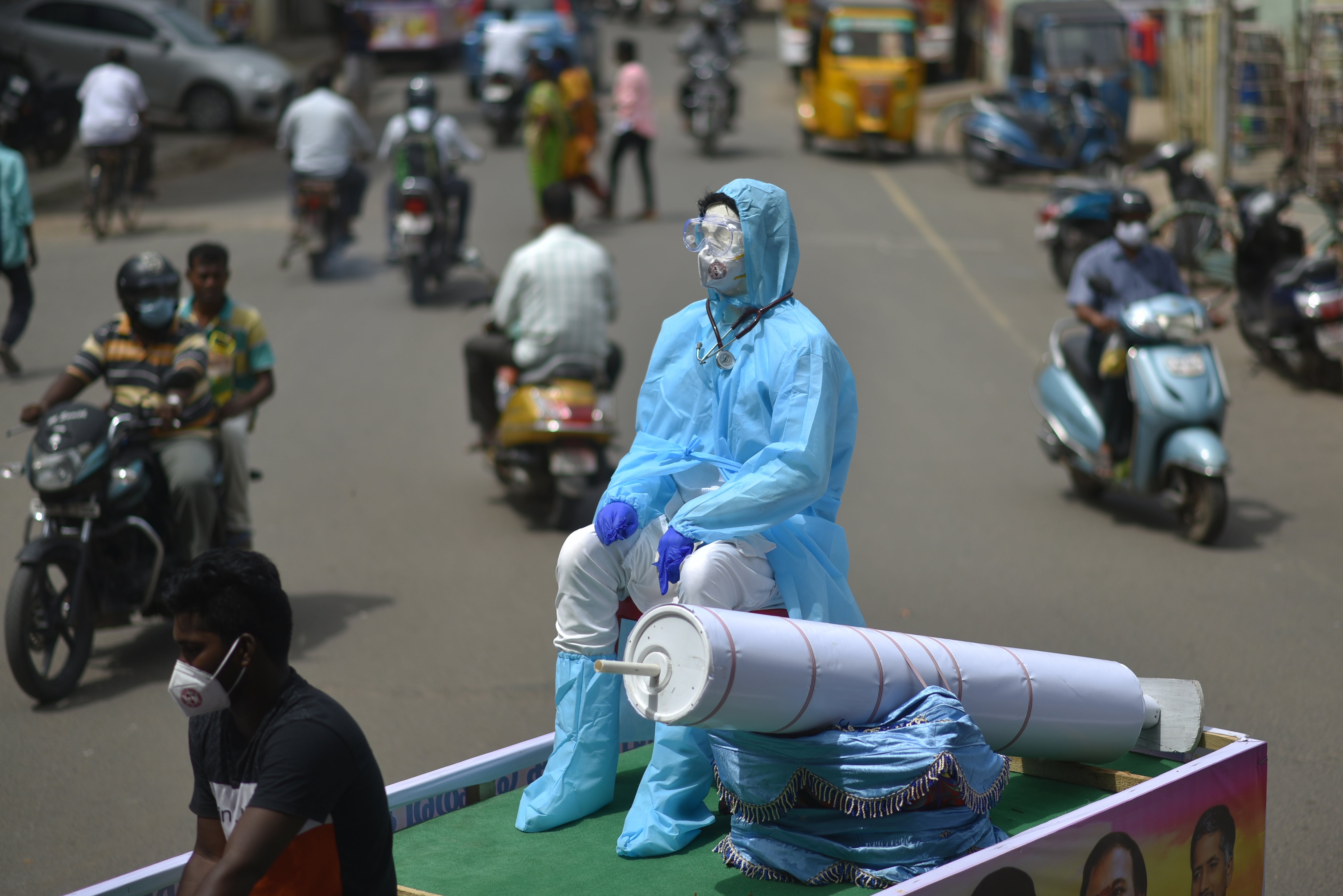 NGO volunteers showcase a mannequin dressed in PPE on a cycle rickshaw during an awareness campaign against the spread of Covid-19 in Chennai, India