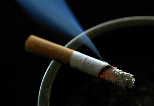 A lit cigarette smouldering on an ashtray