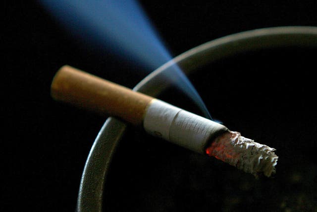 A lit cigarette smouldering on an ashtray