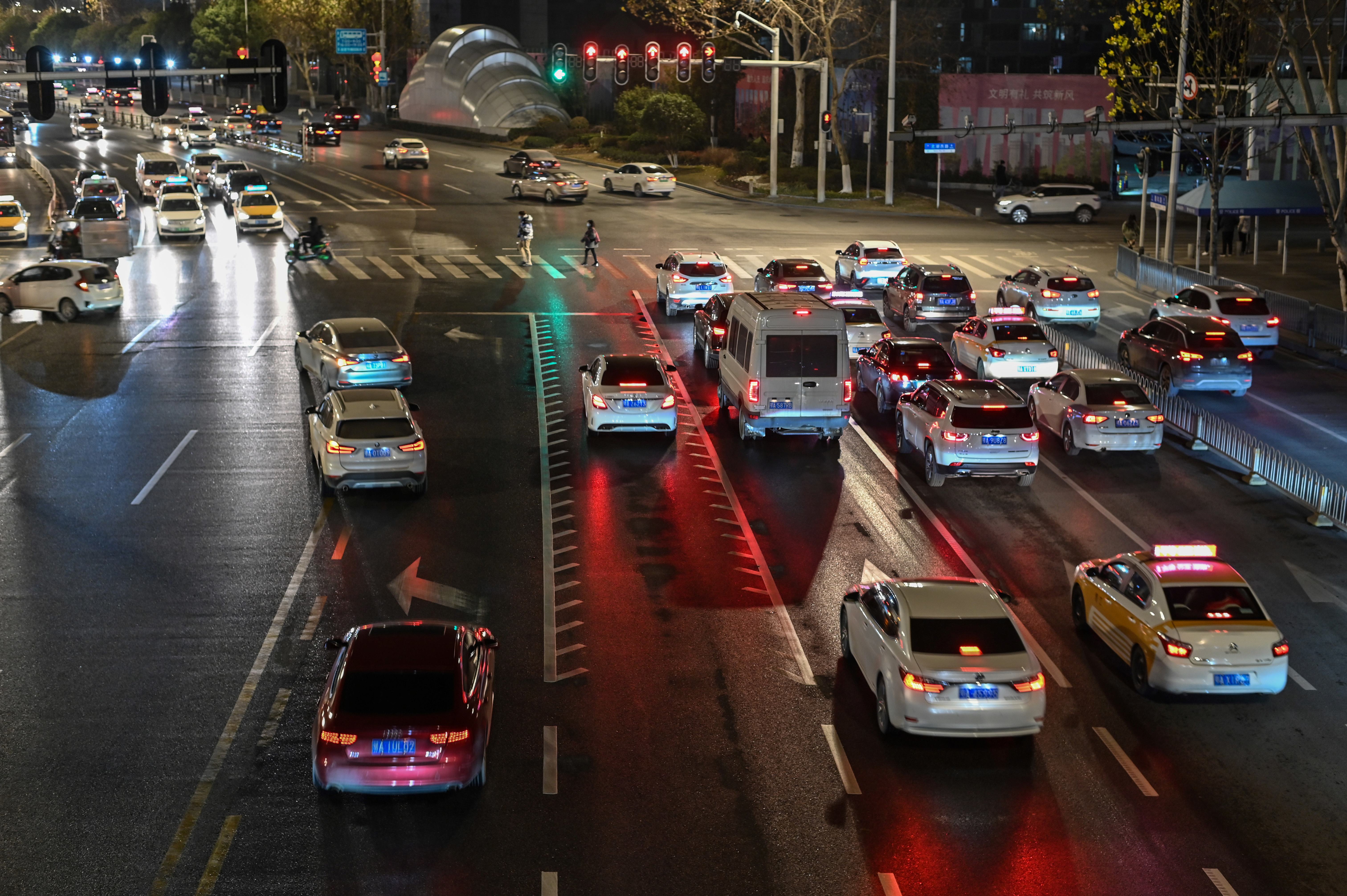 File: This photo taken on 19 January 2021 shows a general view of traffic stopped at a red light on a street in Wuhan, China