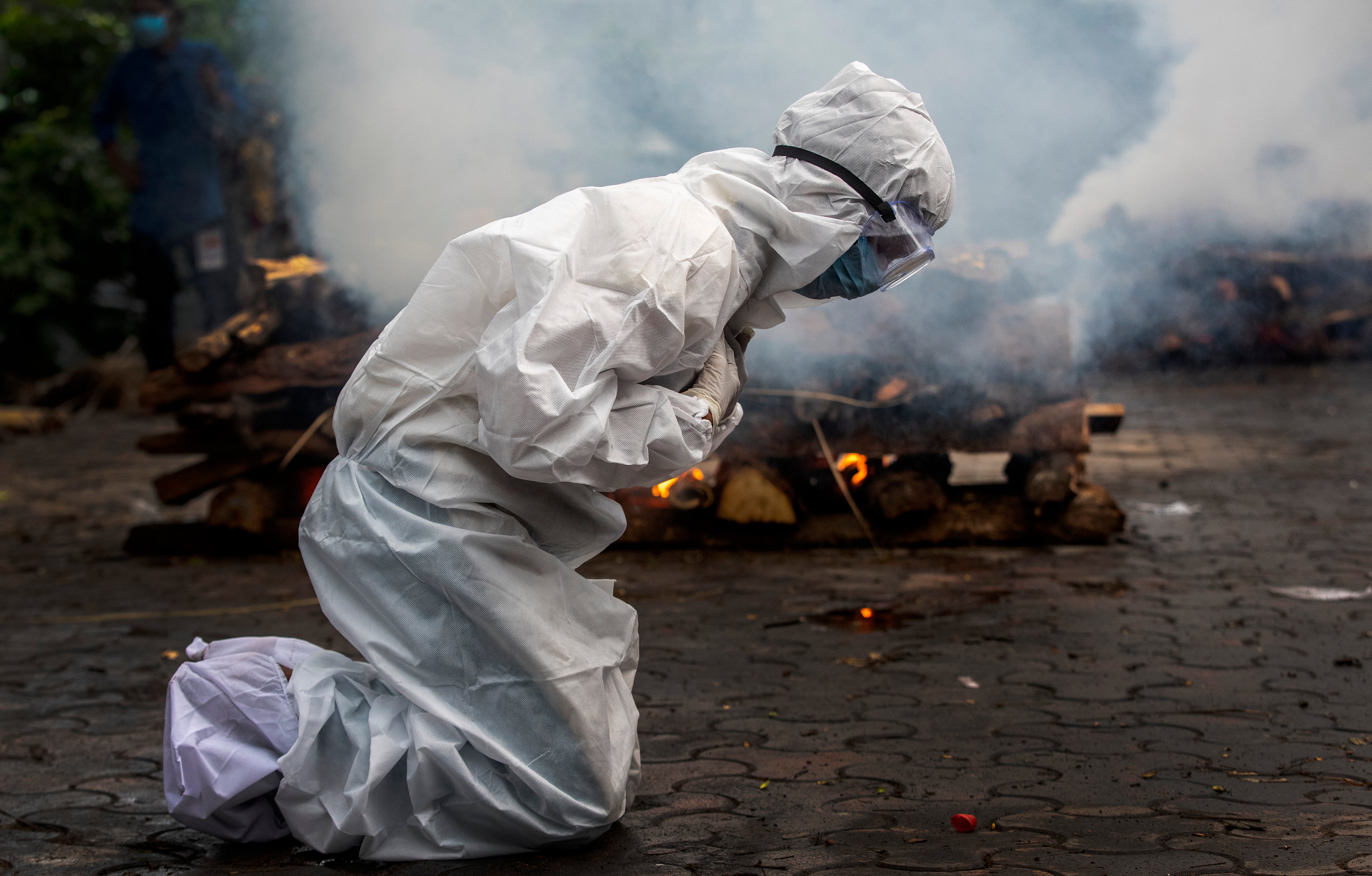 A woman breaks down as she prays before the cremation of a relative who died of Covid in Guwahati