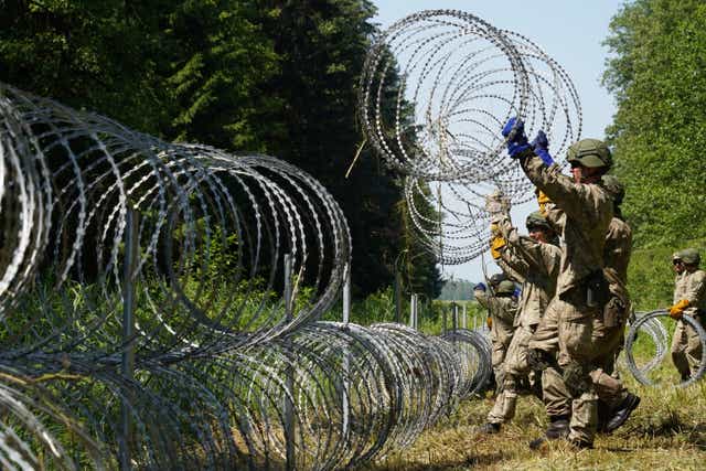 <p>Lithuanian soldiers install razor wire on border with Belarus in Druskininkai</p>