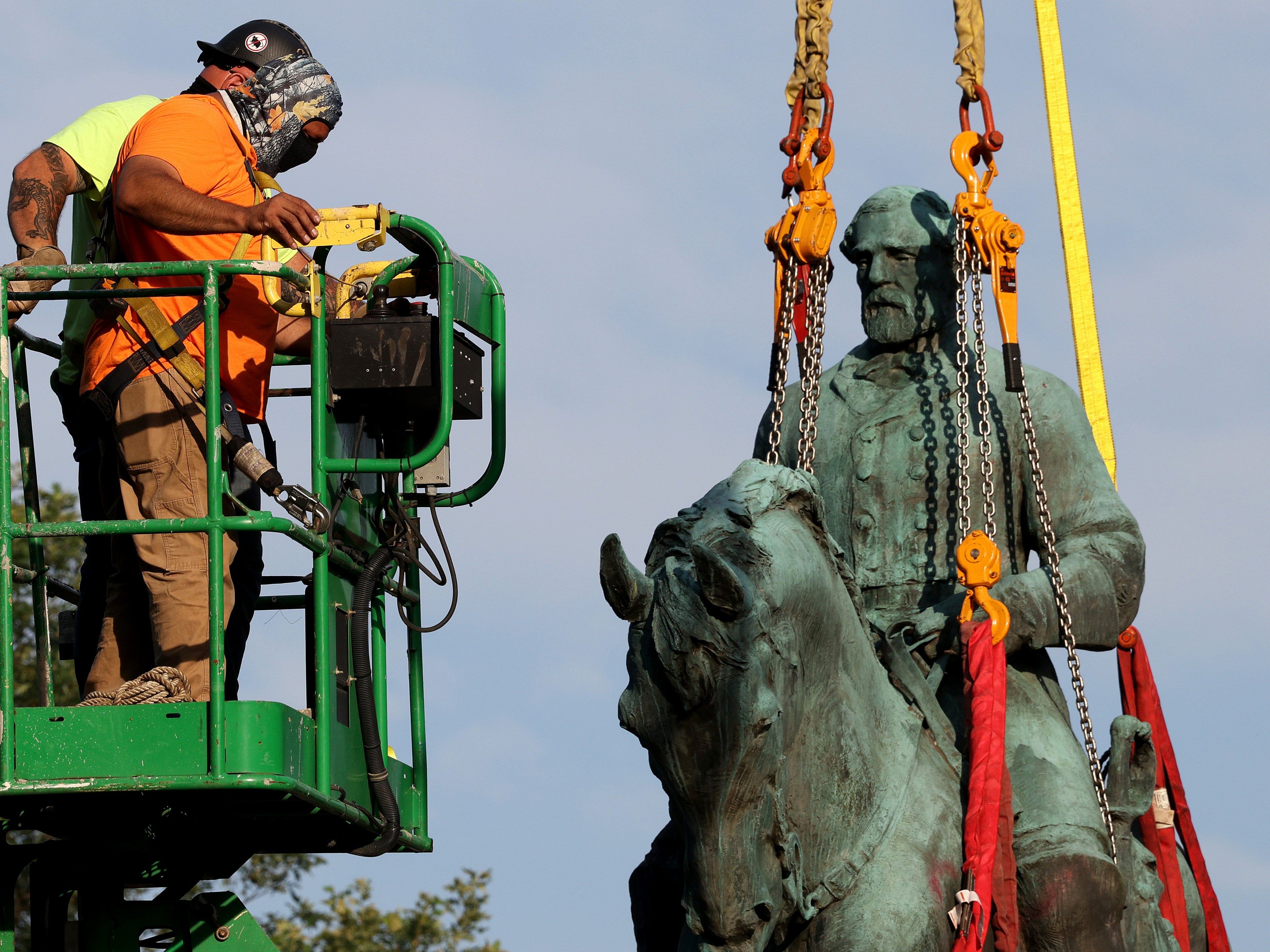 Workers remove a statue of Confederate General Robert E. Lee from Market Street Park July 10, 2021 in Charlottesville, Virginia.