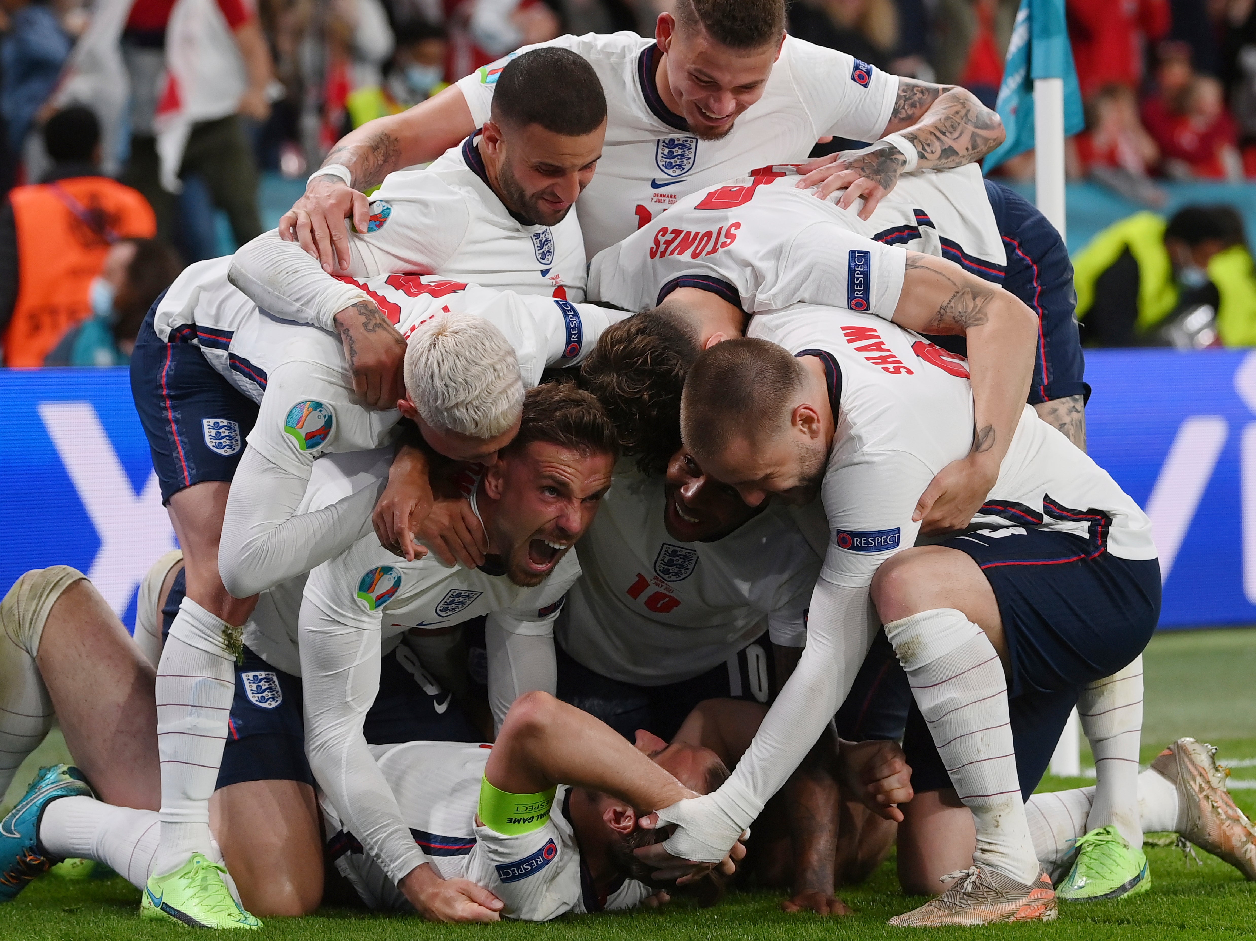 England's Harry Kane, bottom, celebrates with his teammates after scoring his side's second goal during the Euro 2020 soccer semifinal match between England and Denmark at Wembley stadium in London