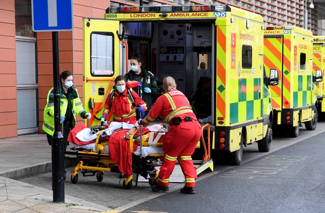 <p>Ambulance workers pictured in January during the Covid wave that cause a huge backlog of NHS treatment</p>