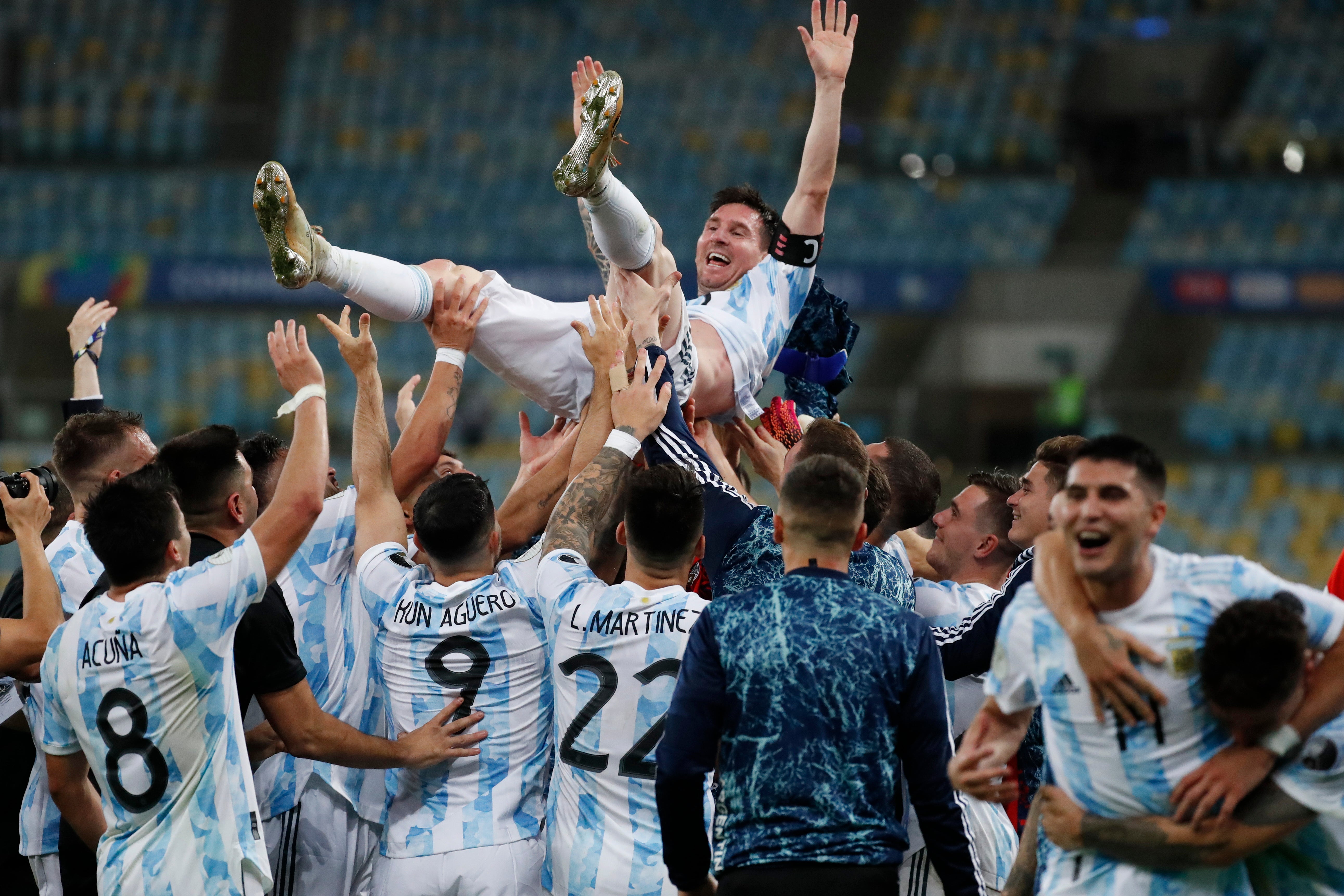 Lionel Messi is thrown in the air by his team-mates