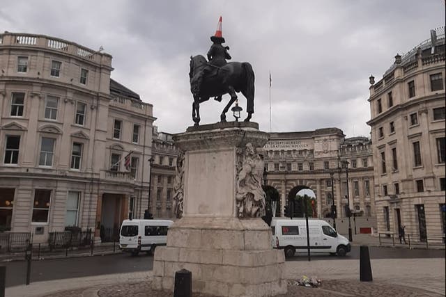 <p>A cone sits on the head of a statue of George IV in Trafalgar Square the morning after the final</p>