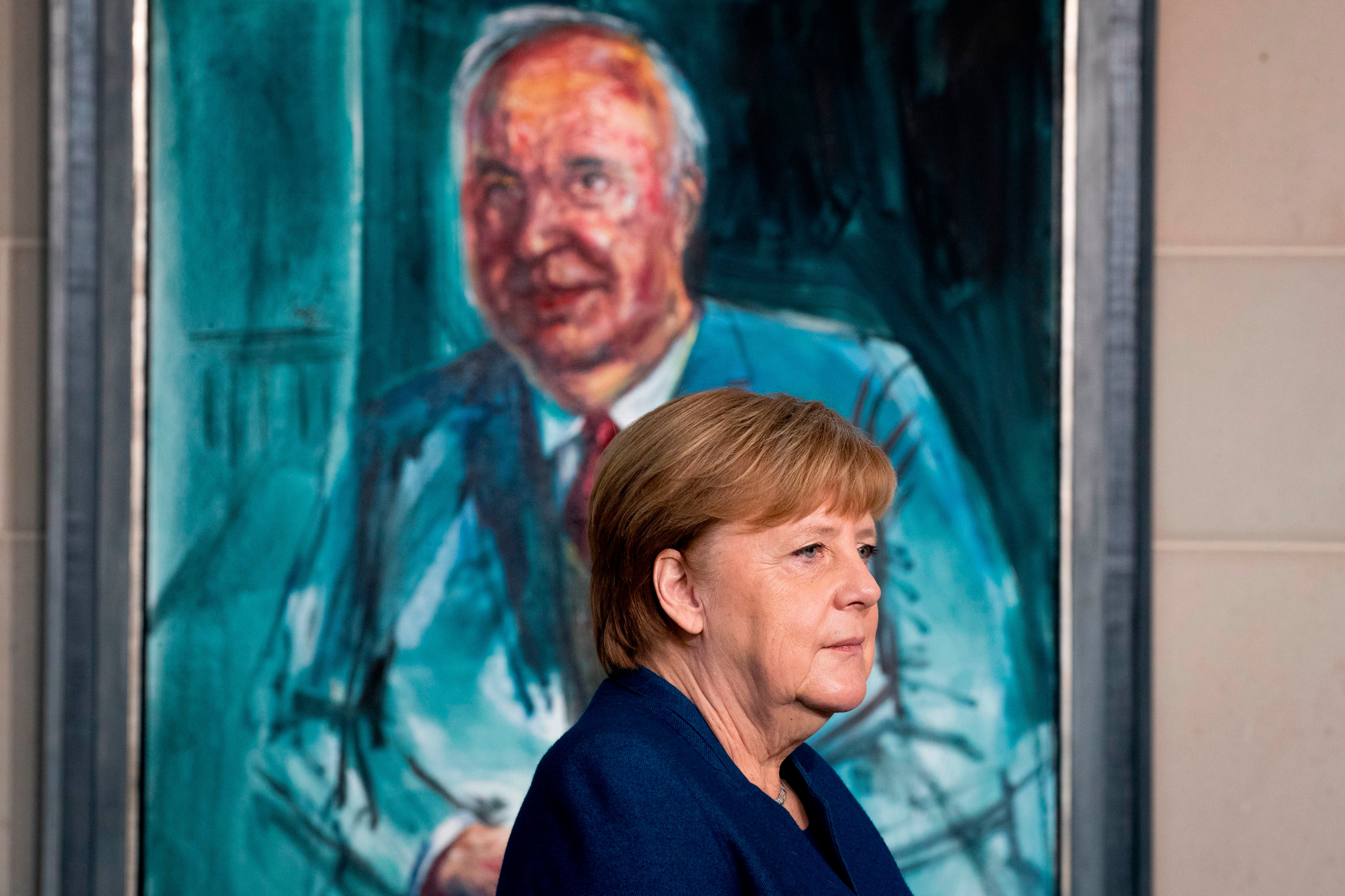 Merkel in front of a painting of Kohl by German artist Albrecht Gehse. Merkel is the second-longest serving chancellor in modern Germany