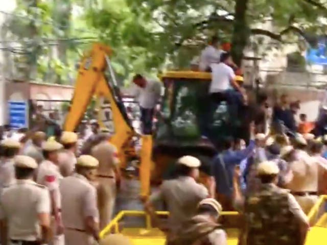 <p>Members of Bharatiya Janata Party (BJP) on a mechanical excavator (JCB) in the lane of Delhi’s water body chief Satyendra Jain attempting to disconnect his water connection as part of their protest against ‘poor water supply’</p>