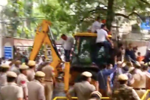 <p>Members of Bharatiya Janata Party (BJP) on a mechanical excavator (JCB) in the lane of Delhi’s water body chief Satyendra Jain attempting to disconnect his water connection as part of their protest against ‘poor water supply’</p>