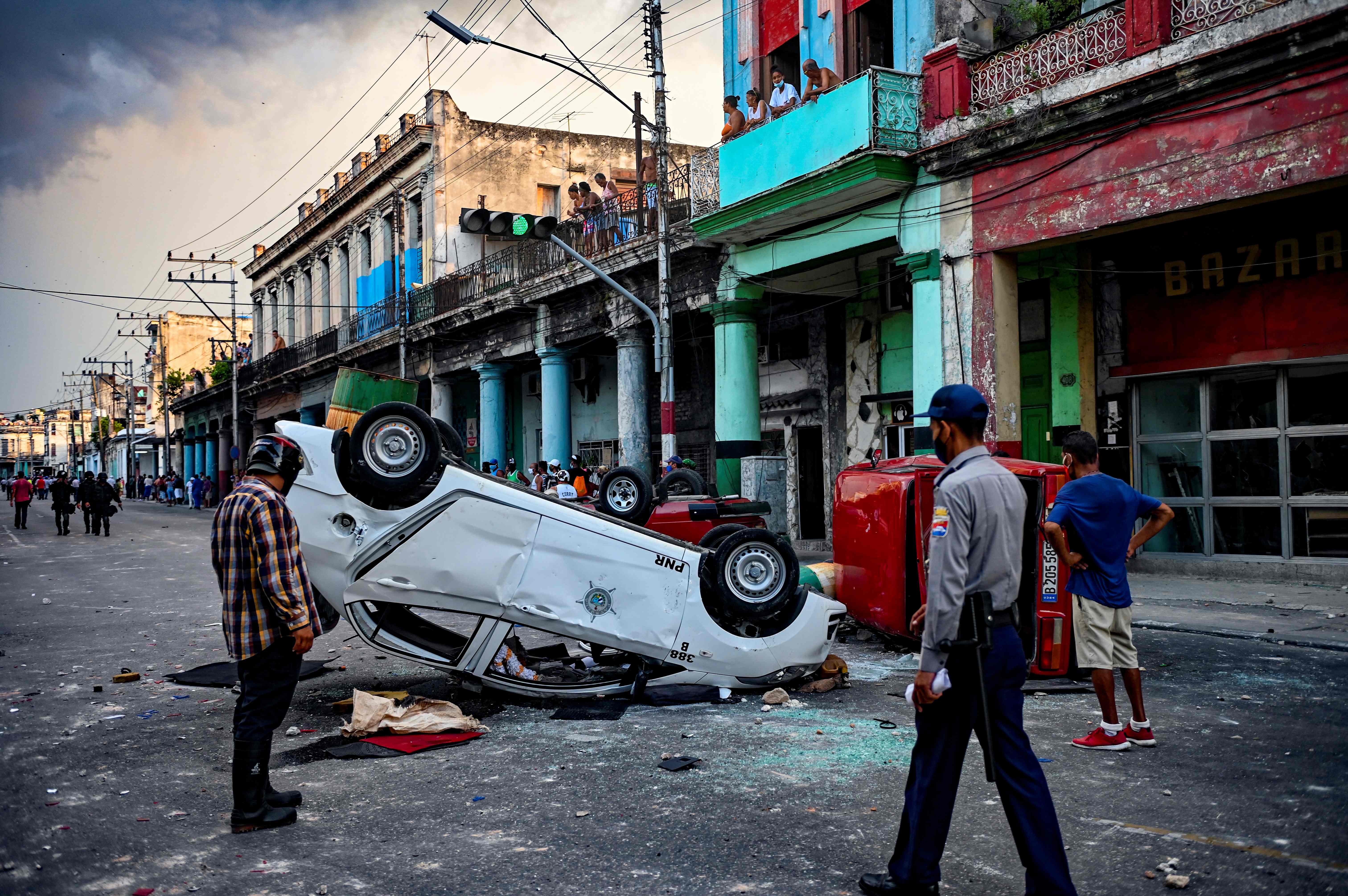<p>Coches de la policía se ven volcados en la calle en el marco de una manifestación contra el presidente cubano Miguel Díaz-Canel en La Habana, el 11 de julio de 2021.</p>