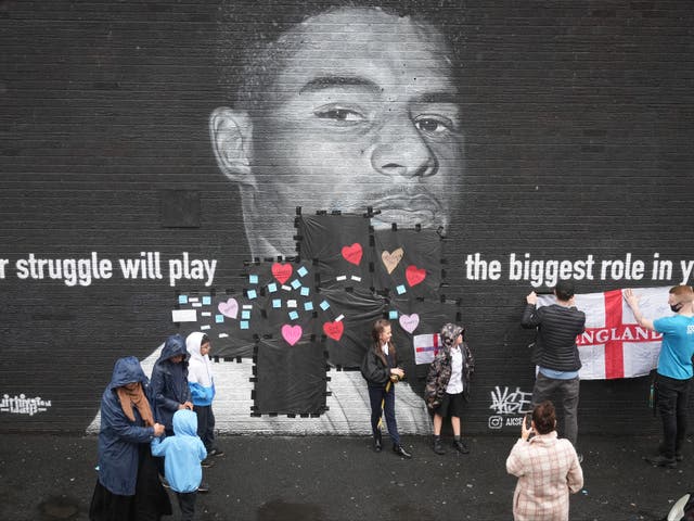 <p>Local residents put messages of support on the plastic that covers offensive graffiti on the vandalised mural of Manchester United striker and England player Marcus Rashford on the wall of a cafe on Copson Street, Withington</p>