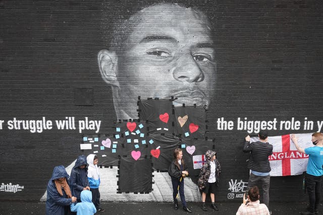 <p>Local residents put messages of support on the plastic that covers offensive graffiti on the vandalised mural of Manchester United striker and England player Marcus Rashford on the wall of a cafe on Copson Street, Withington</p>