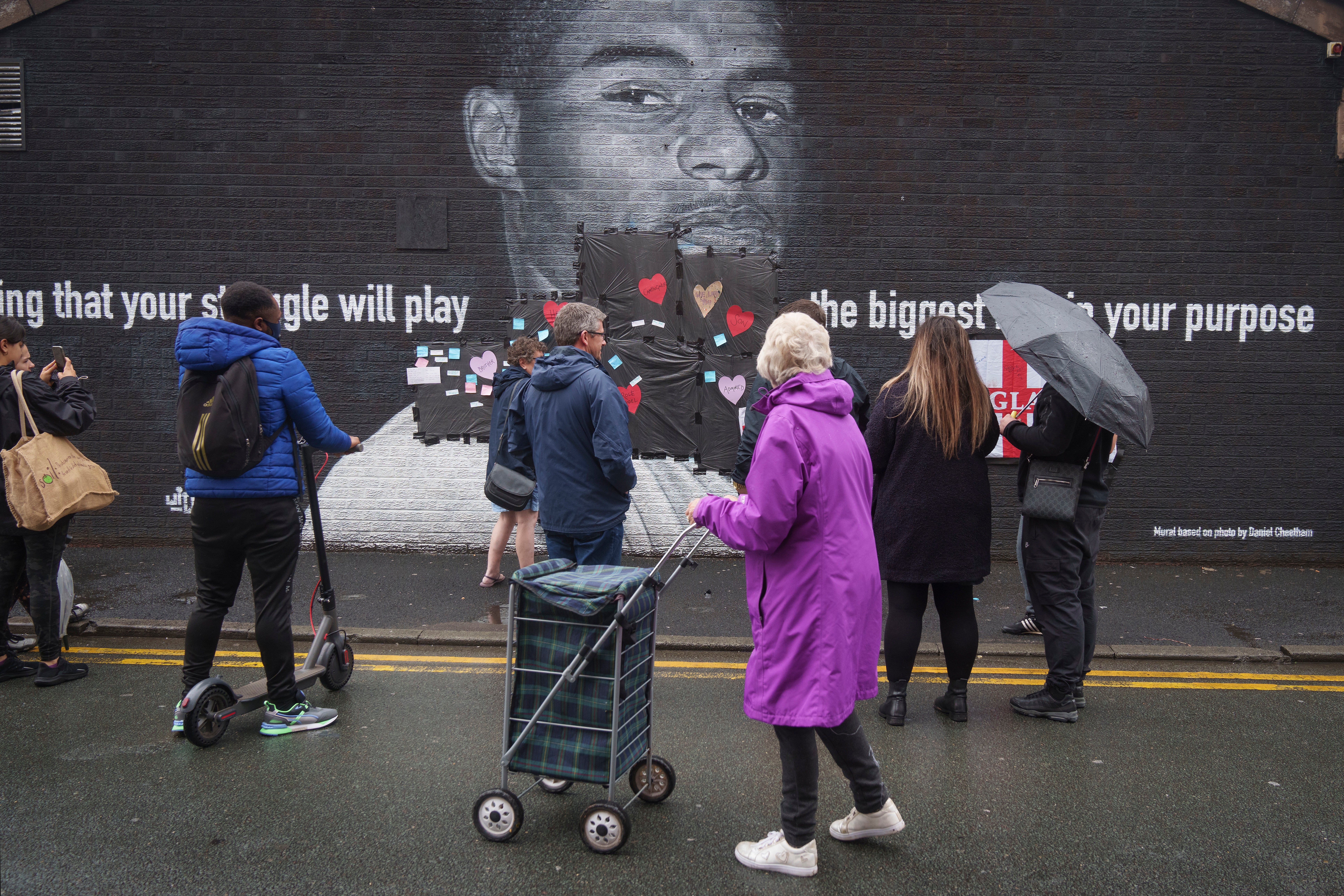 Local residents put messages of support on the plastic that covers offensive graffiti on the mural of striker Marcus Rashford in Withington, Manchester