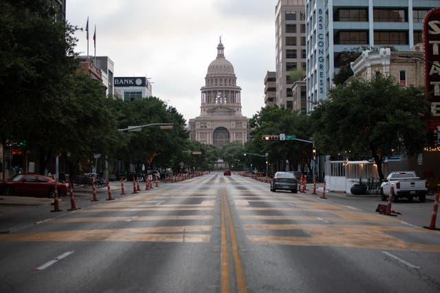 <p>Cars drive on Congress Avenue in front of the Texas Capitol building on July, 14, 2020 in Austin, Texas. </p>