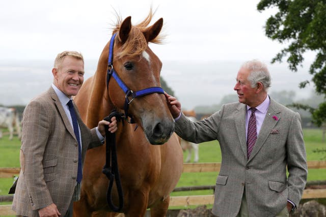 <p>Prince Charles, right, is introduced to Victoria, a Suffolk Punch horse by farmer and television personality Adam Henson, left, during a visit to Cotswold Farm Park in Guiting Power on 1 July 2020</p>
