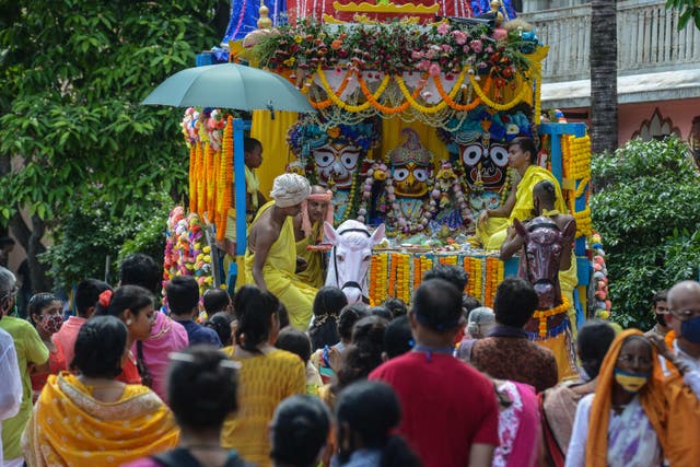 <p>Devotees watch the pulling of a chariot during the annual Lord Jagannath Rath Yatra (procession) after the temple management decided against taking out the procession on the roads in Siliguri city on 12 July 2021</p>