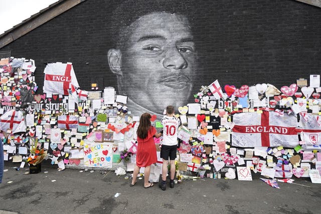 <p>A mural of Marcus Rashford which had been defaced is adorned with messages of support</p>