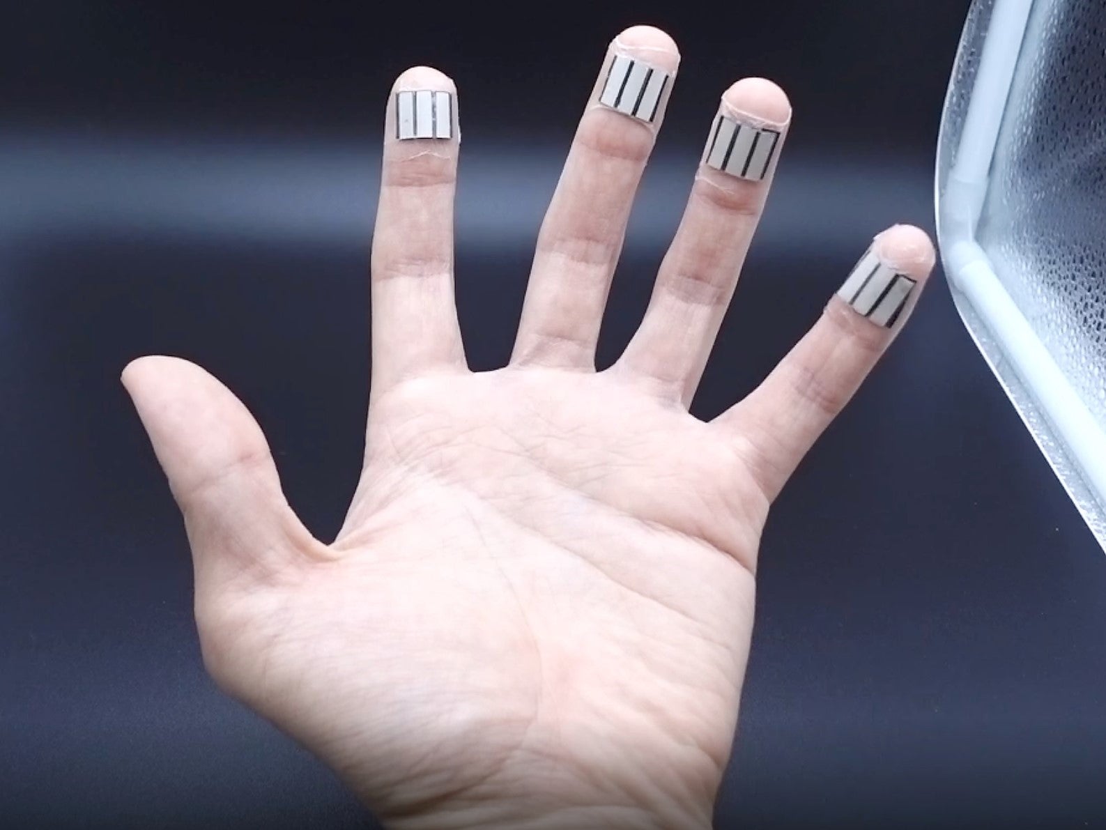 A left hand with 4 BFCs wrapped onto four individual fingers to collect energy simultaneously from multiple fingers