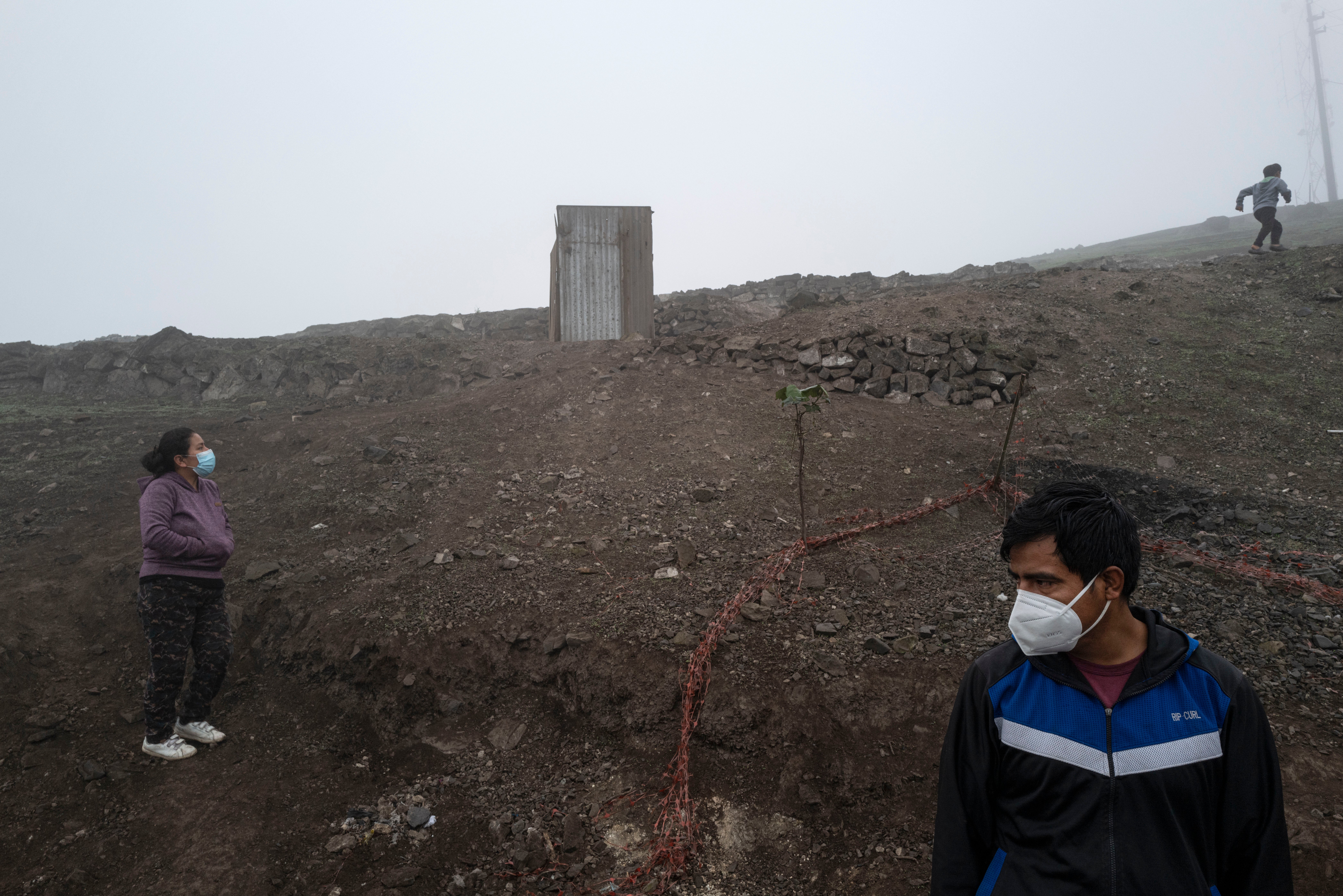 Rosel Ccatamayo and his wife, Marimar Avila, stand in an area near their home in Lima