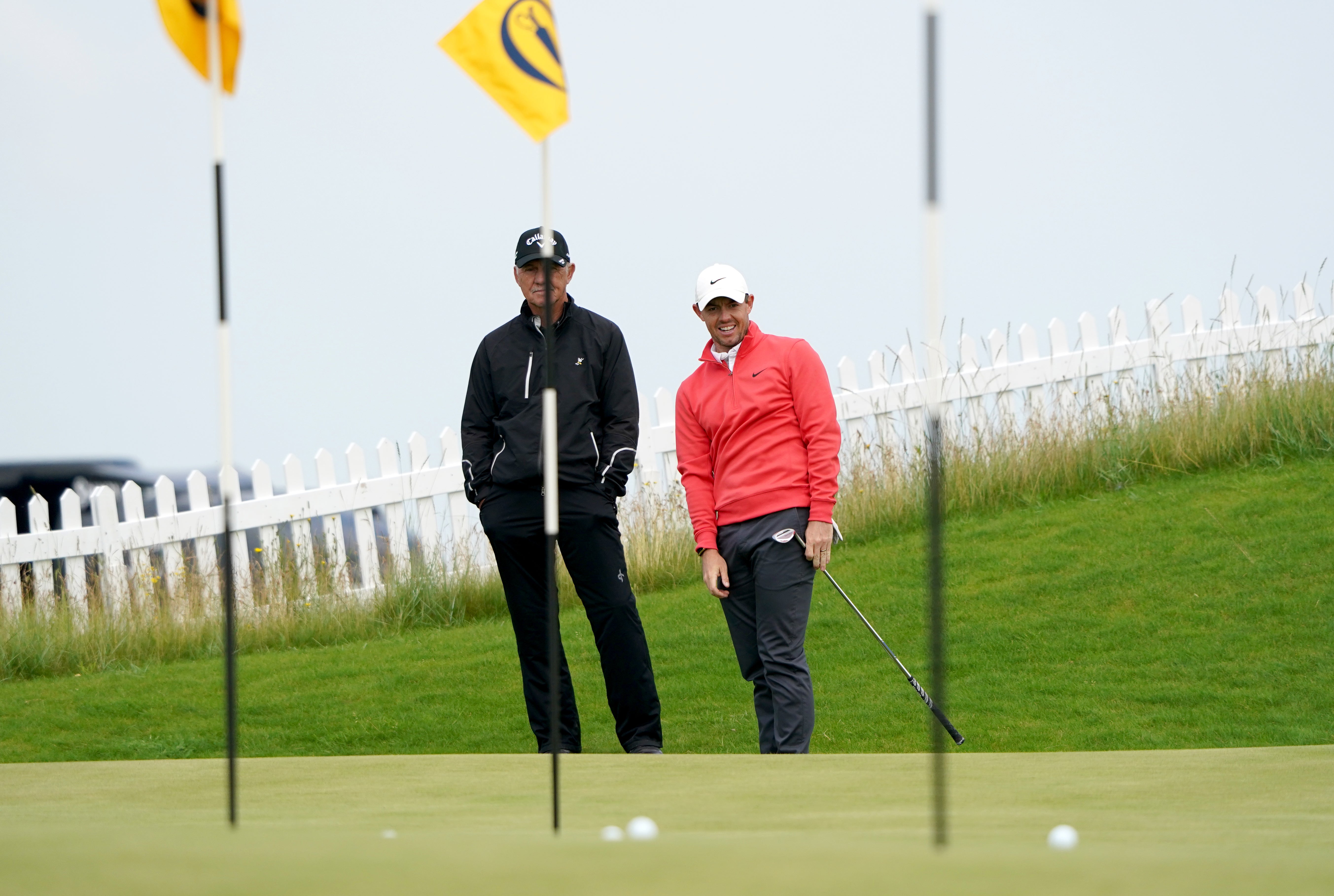 Rory McIlroy practises chipping watched by coach Pete Cowen