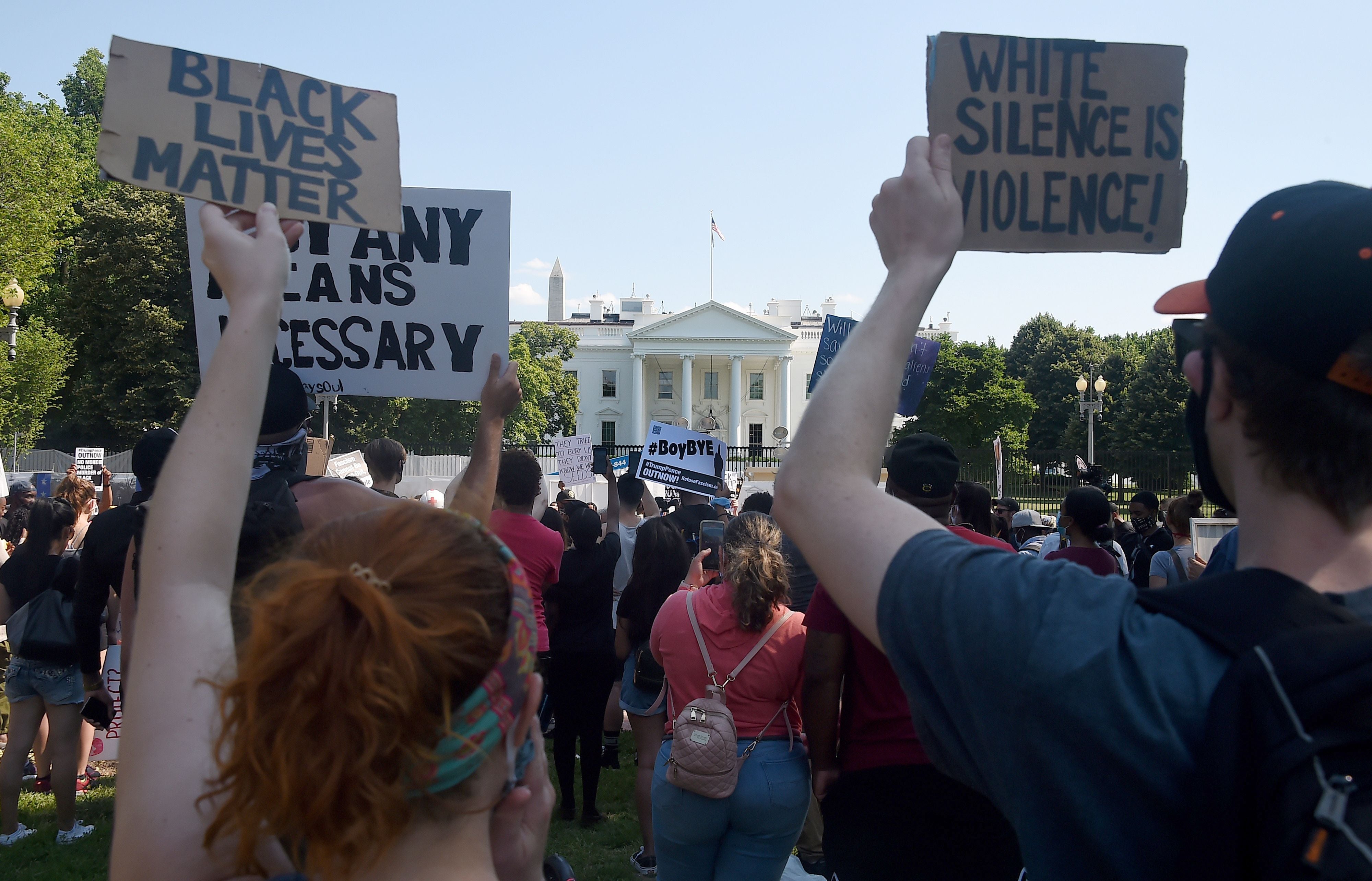 <p>Protesters hold placards in Lafayette Park, across from the White House to protest against police brutality and US President Donald Trump's 74th birthday on June 14, 2020 in Washington, DC</p>