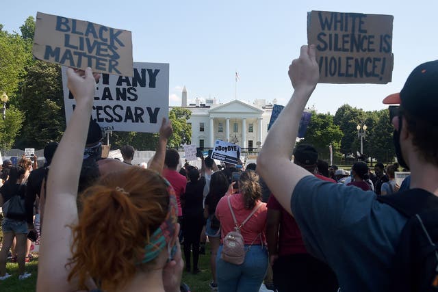 <p>Protesters hold placards in Lafayette Park, across from the White House to protest against police brutality and US President Donald Trump's 74th birthday on June 14, 2020 in Washington, DC</p>