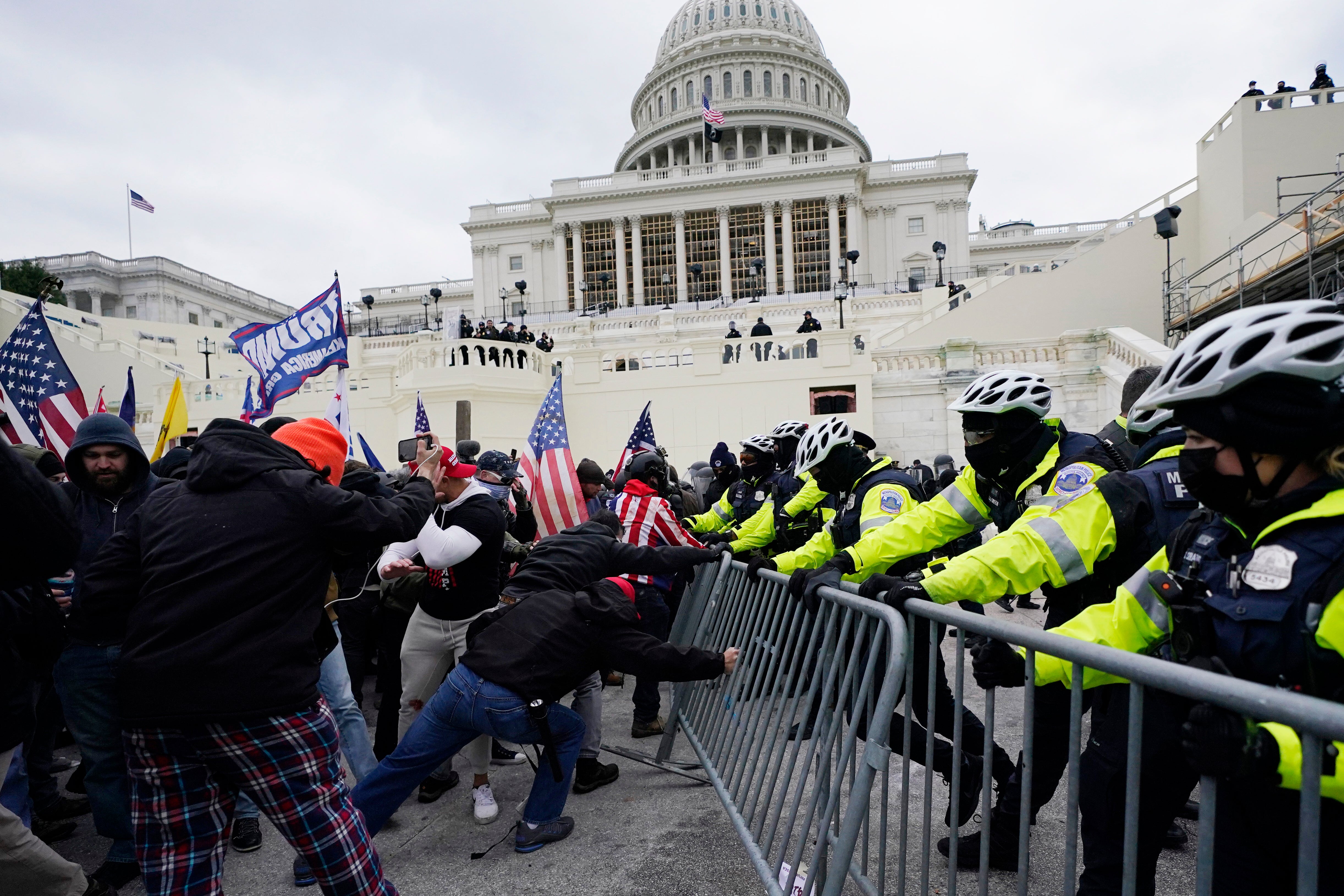 File: In this 6 January 2021 photo, supporters loyal to former president Donald Trump try to break through a police barrier at the Capitol in Washington