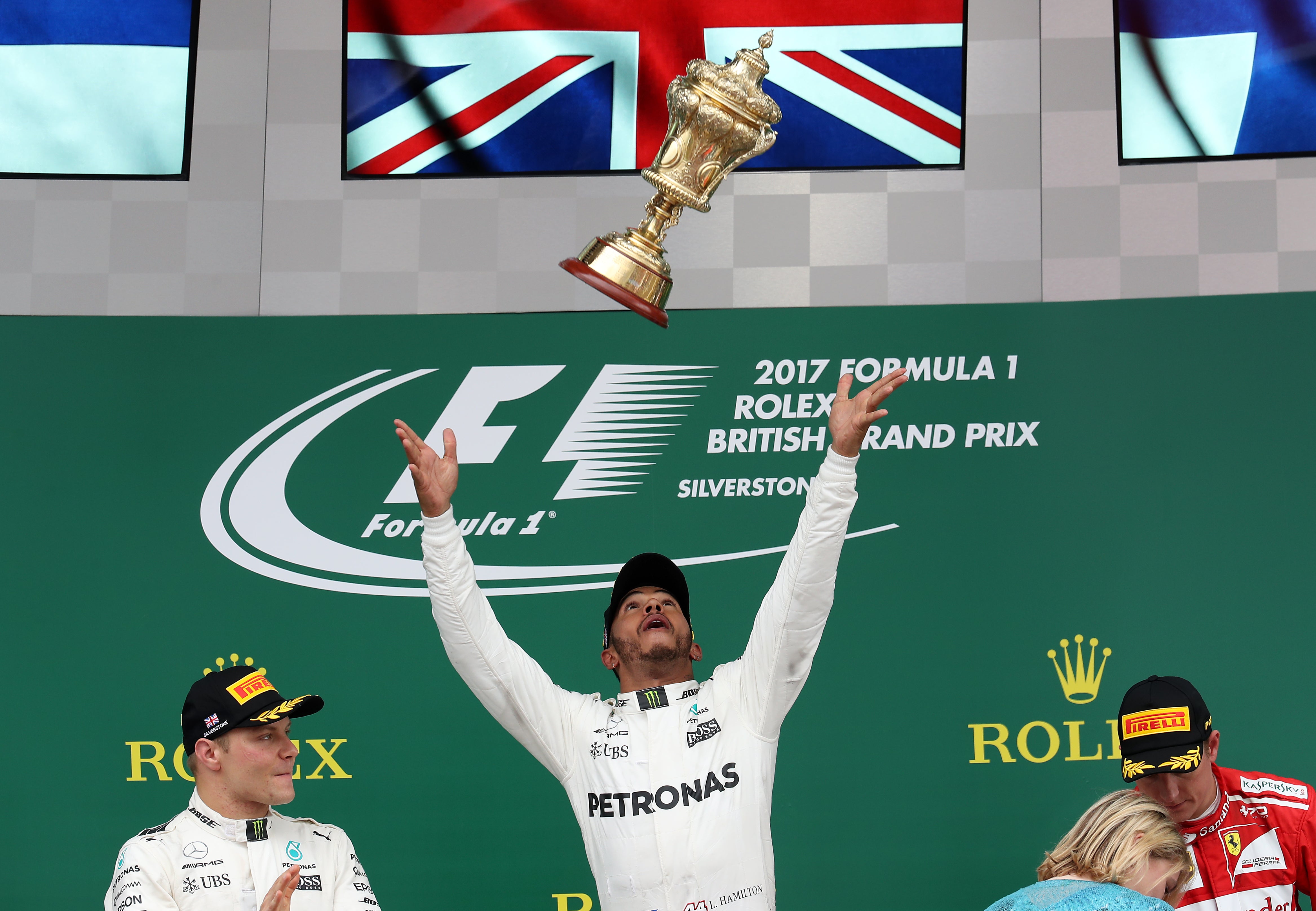 Lewis Hamilton (centre) celebrates his victory on the podium in 2017