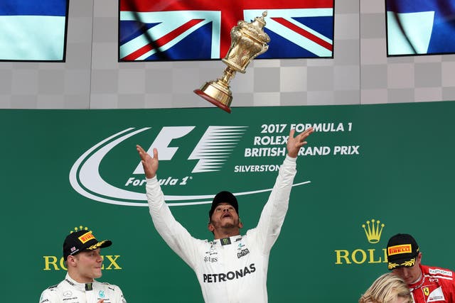 <p>Lewis Hamilton (centre) celebrates his victory on the podium in 2017</p>