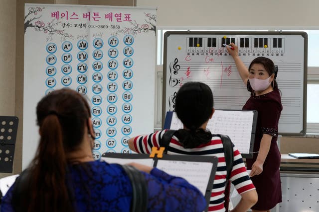 <p>Ko Jeong Hee, right, a defector who teaches accordion, gives a class at the Inter-Korean Cultural Integration Centre in Seoul, South Korea, on 10 June 2021</p>
