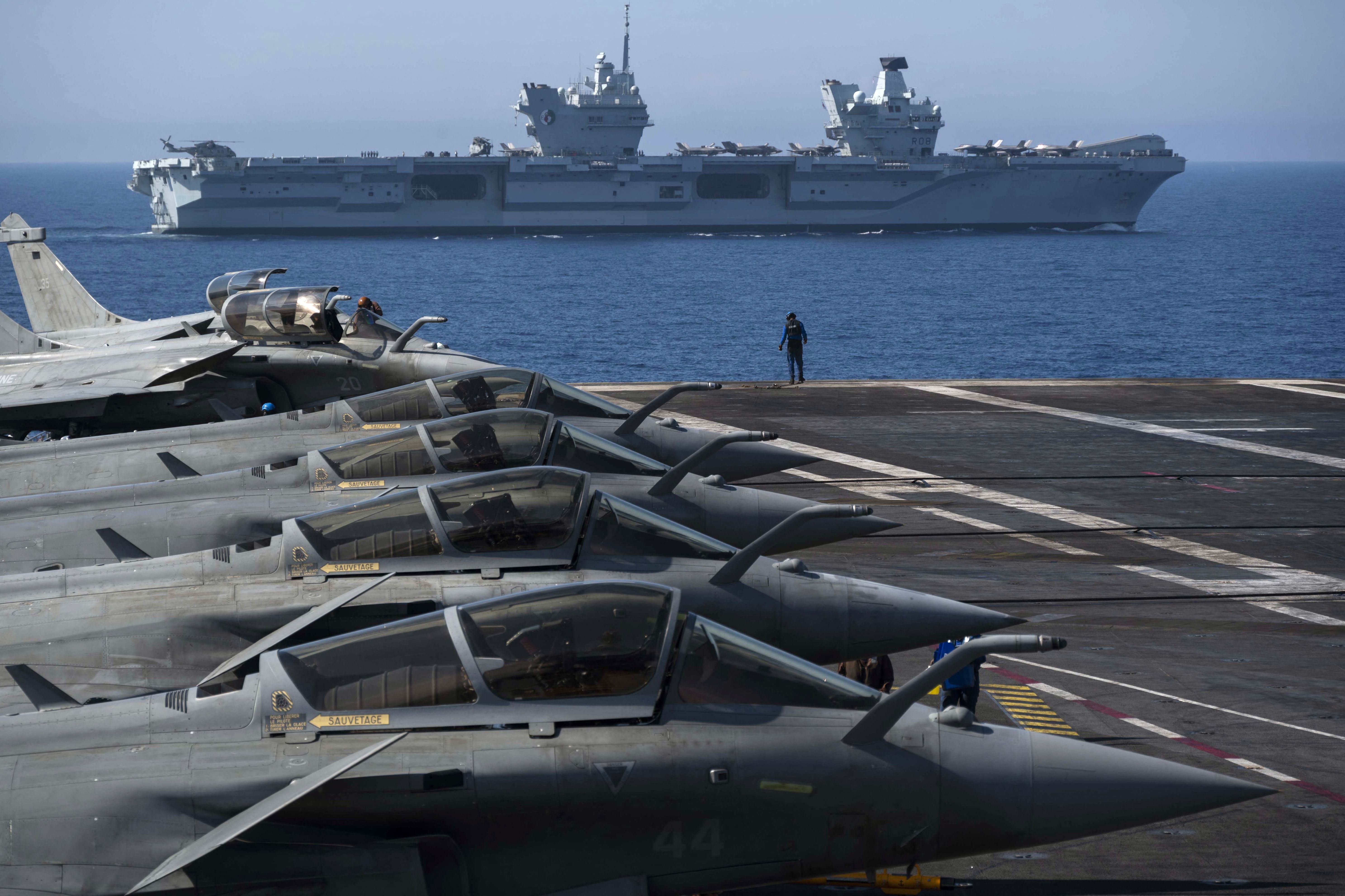 File: The French aircraft carrier Charles de Gaulle is seen with the UK Royal Navy's aircraft carrier HMS Queen Elizabeth in the background, during the exercise ‘Gallic strike’ off the coast of Toulon on 3 June 2021