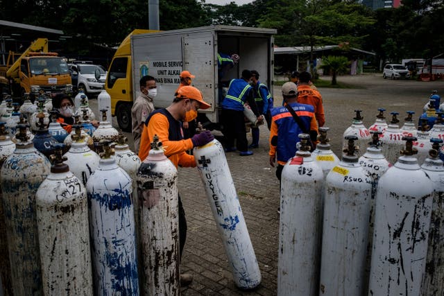 <p>Members of Indonesia’s national rescue organisation offload oxygen tanks to be distributed to hospitals in Jakarta on 13 July 2021</p>
