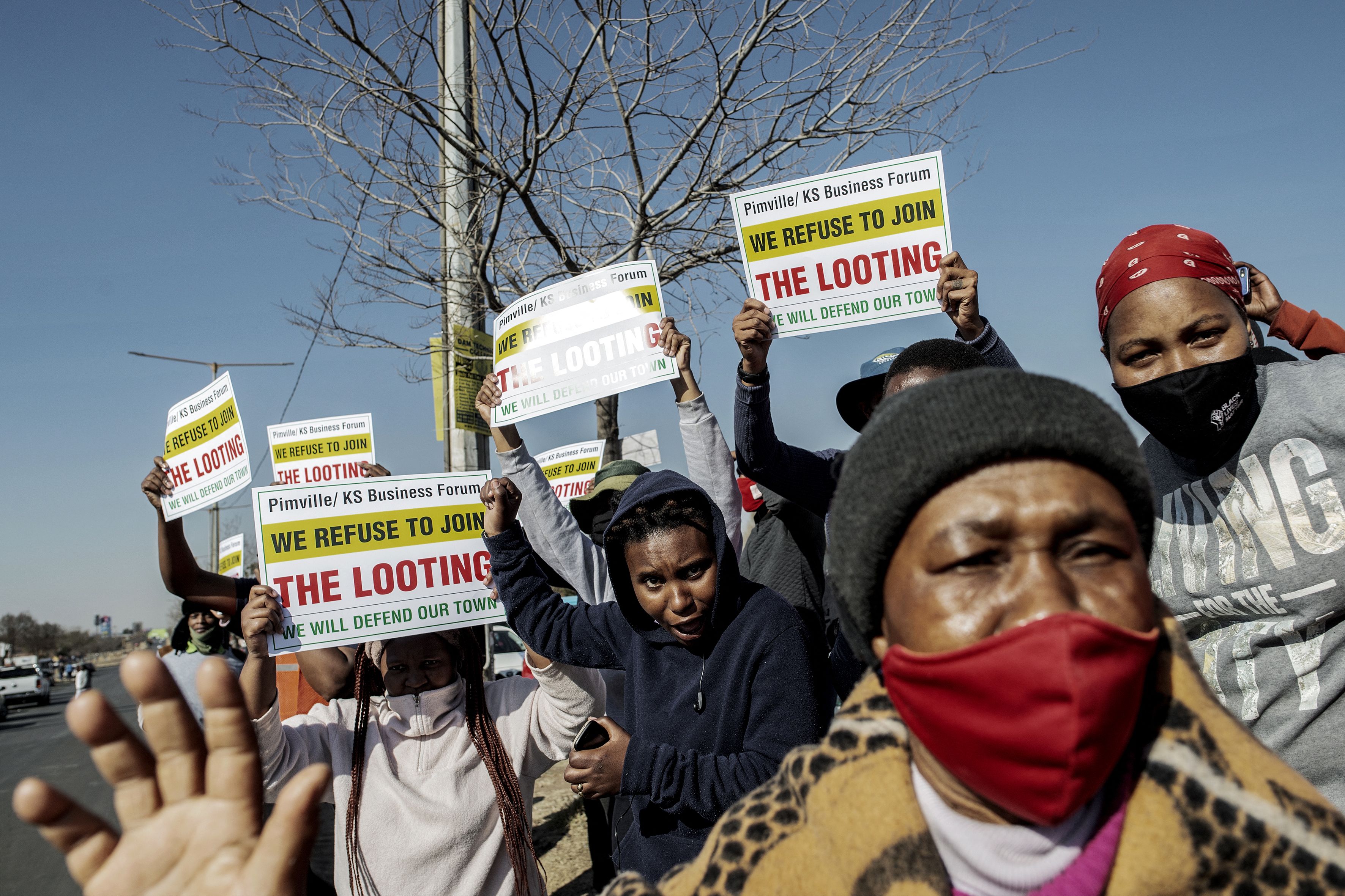 Residents of Soweto shout slogans in front of Maponya Mall