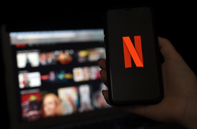 <p>FILE: A computer and a mobile phone screen display the Netflix logo on 31 March 2020 in Arlington, Virginia</p>