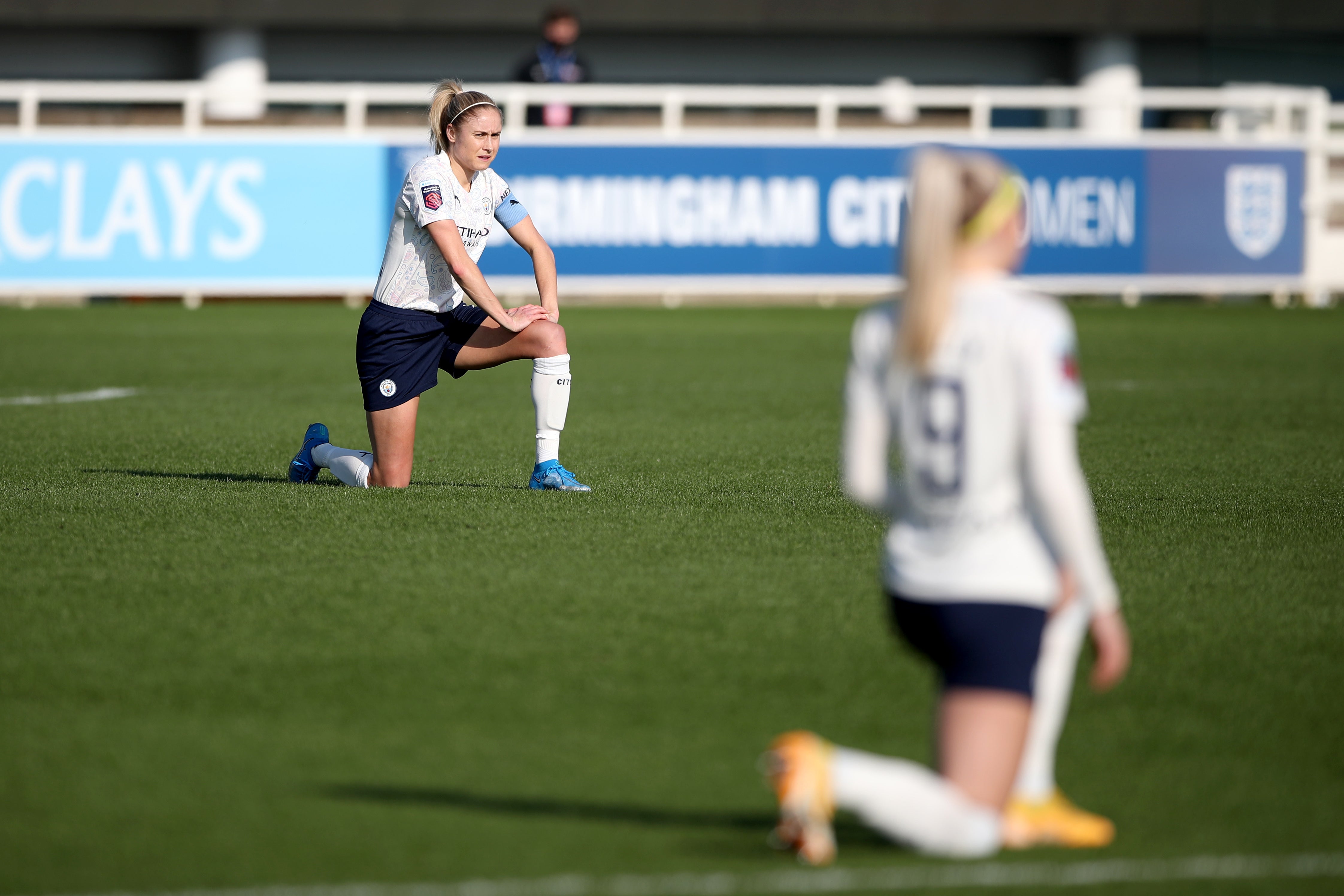 Manchester City’s Steph Houghton, left, takes the knee