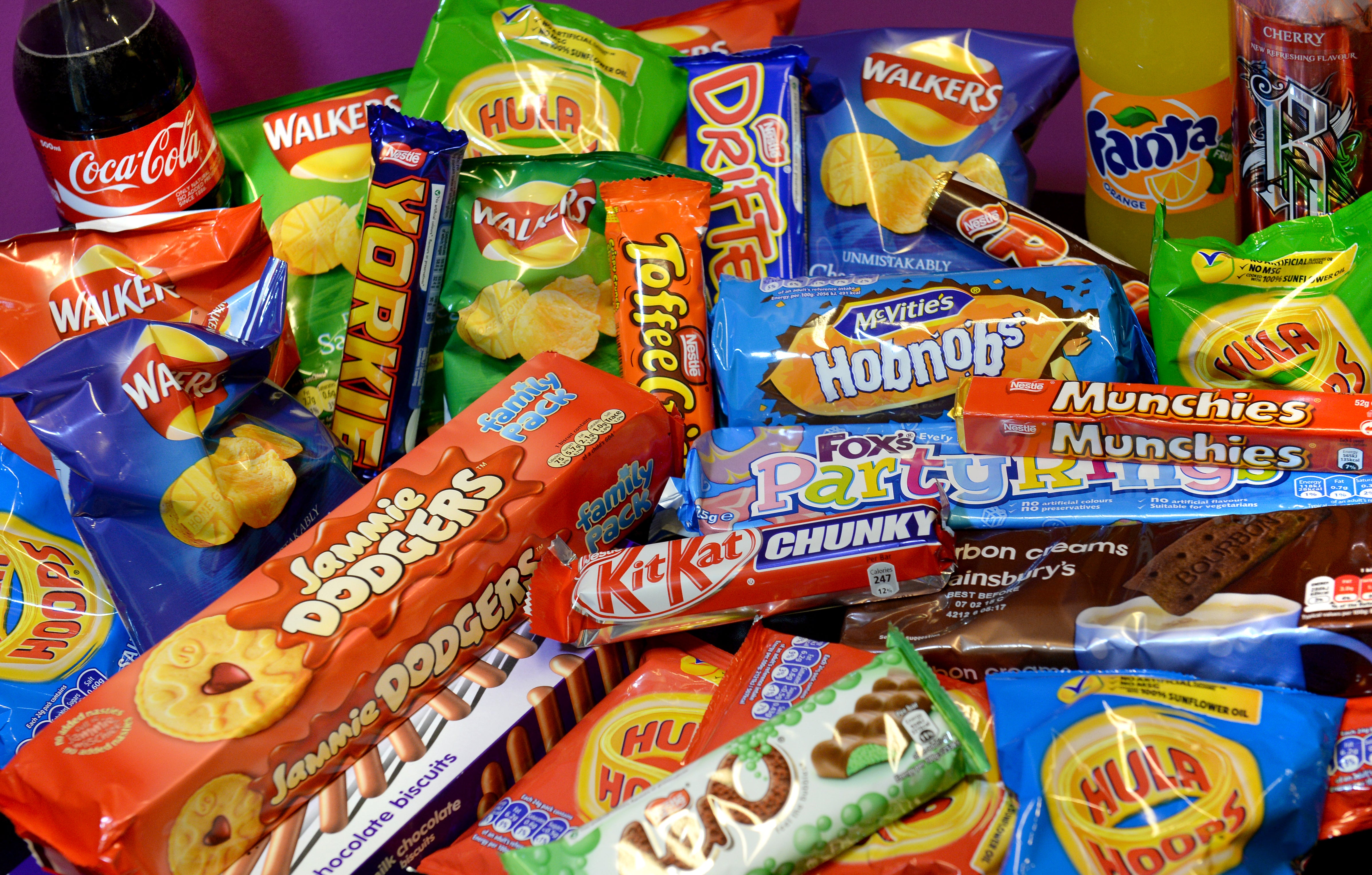 A collection of biscuits, crisps, chocolate bars and carbonated drinks